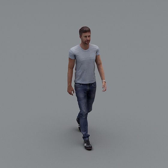 Casual young man in grey t-shirt and blue jeans walking on grey background