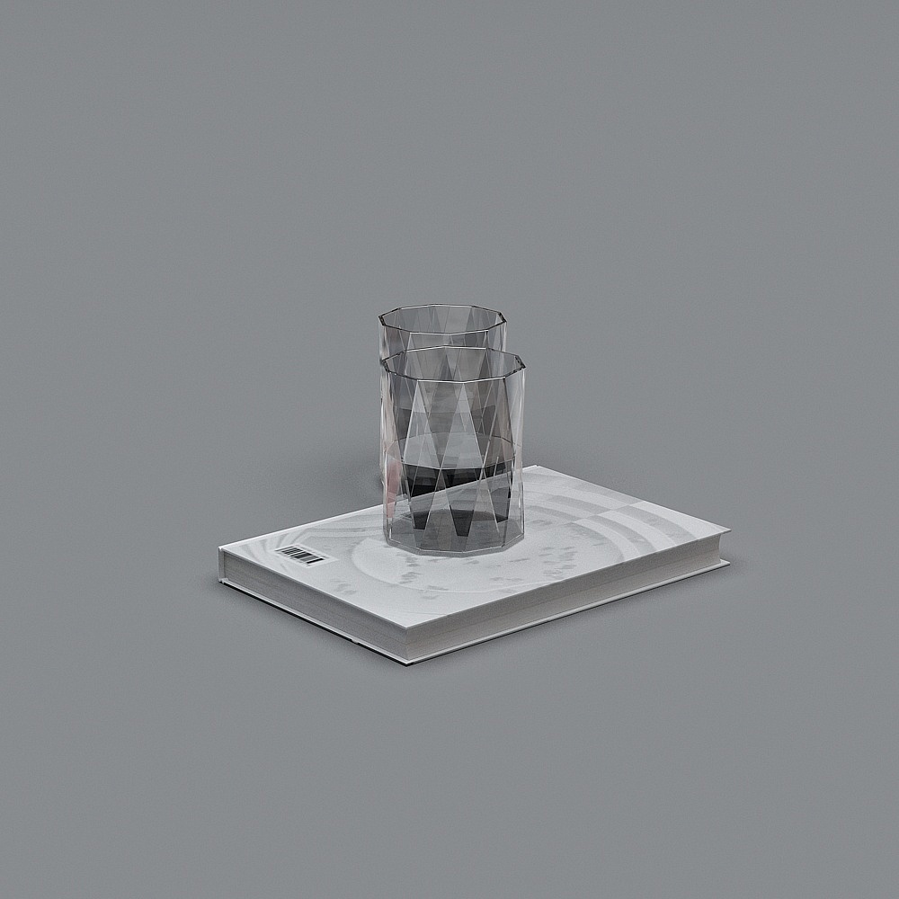 Two clear glass tumblers with geometric pattern on white book on grey background