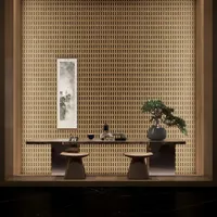 Zen tea room with wooden wall, long wood table, two stools, bonsai tree, and scroll