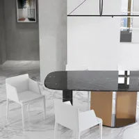 Close up of black marble dining table with white chairs on a white marble floor