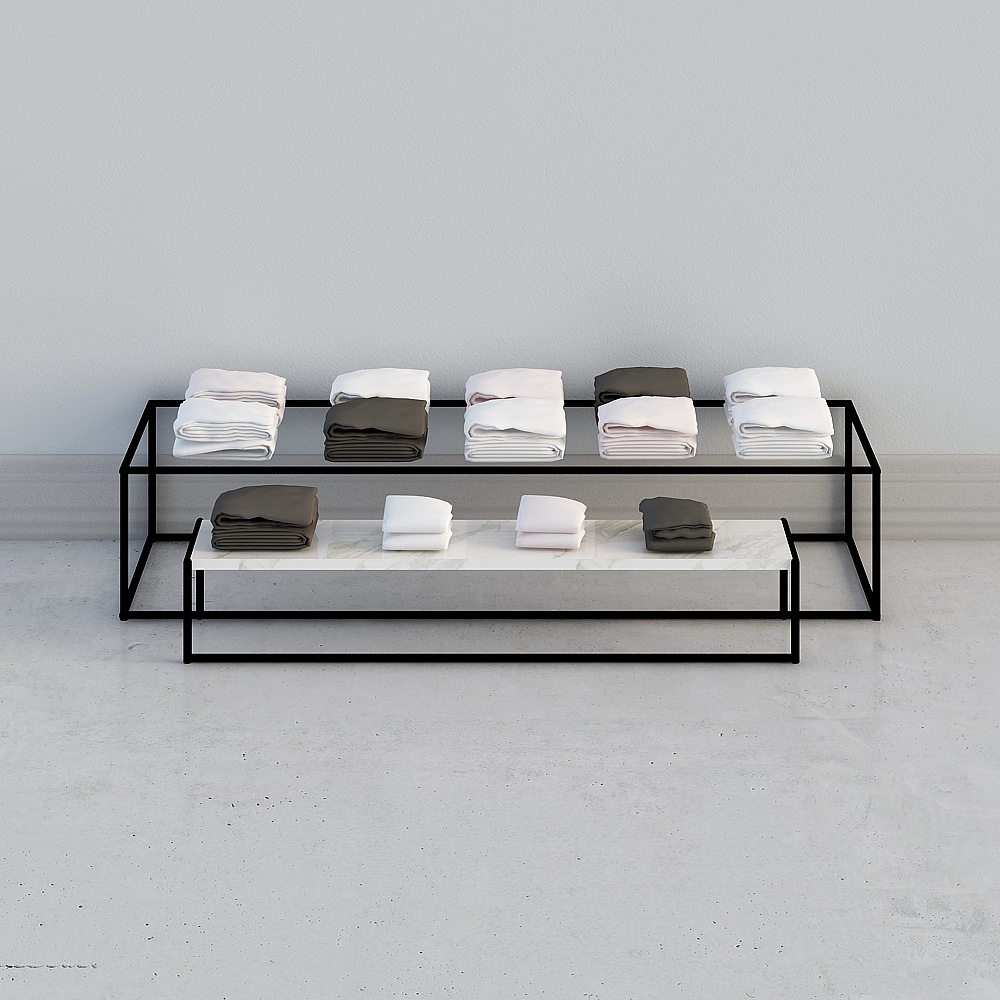 Modern black metal display table with marble shelf holding folded towels on grey background