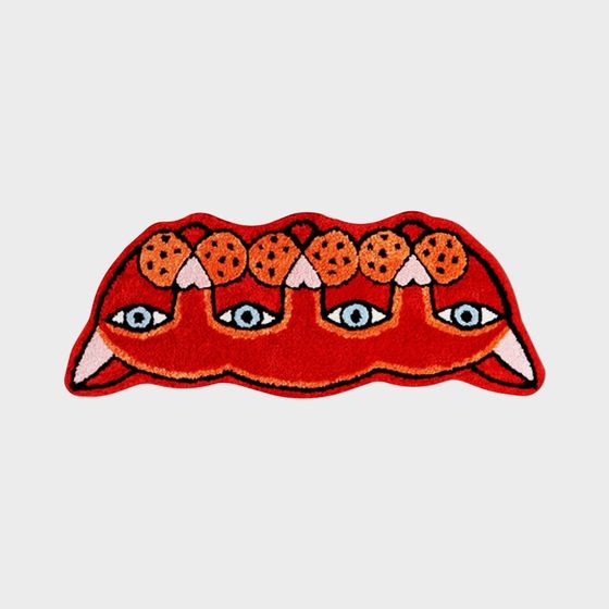 Red monster rug with eyes and teeth on grey background