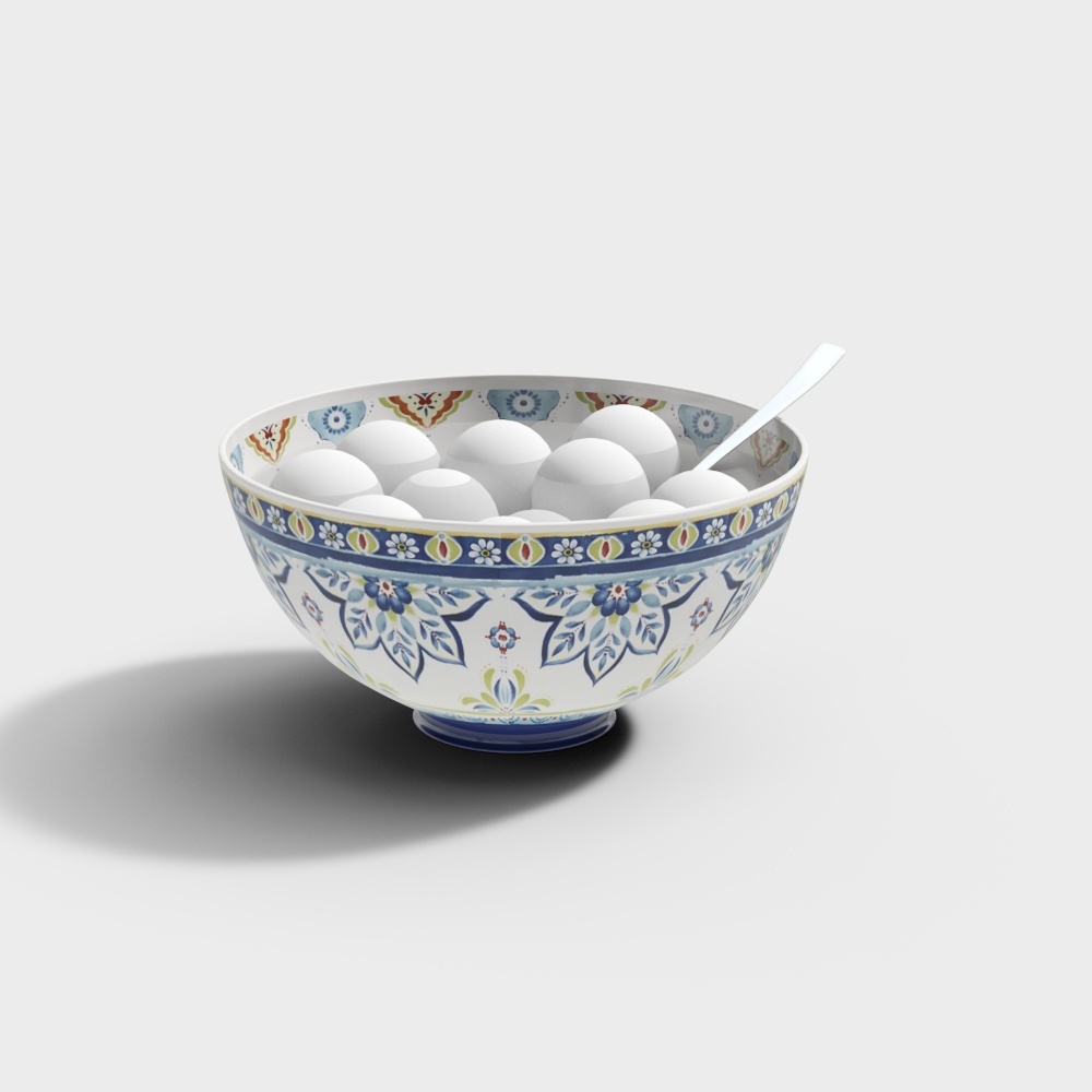 White ceramic bowl with blue floral pattern holding white eggs and spoon on grey background