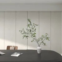 Close up of a black desk with an open book, white vase, and green branches