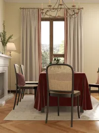 Traditional dining room with red tablecloth chairs fireplace ceiling light curtains and a large window