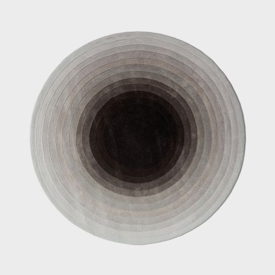 Round grey rug with concentric circle pattern and soft texture on white background