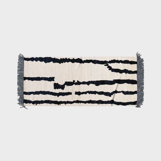 Cream cotton rug with dark blue horizontal stripes and grey tassels on light grey background