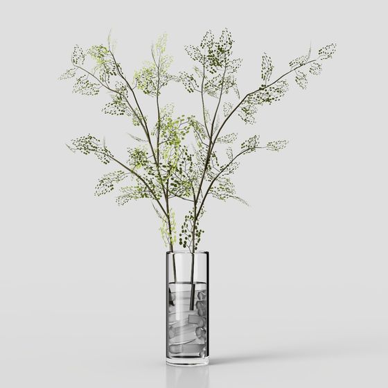 Tall green leafy branches in clear glass vase with white stones on grey background