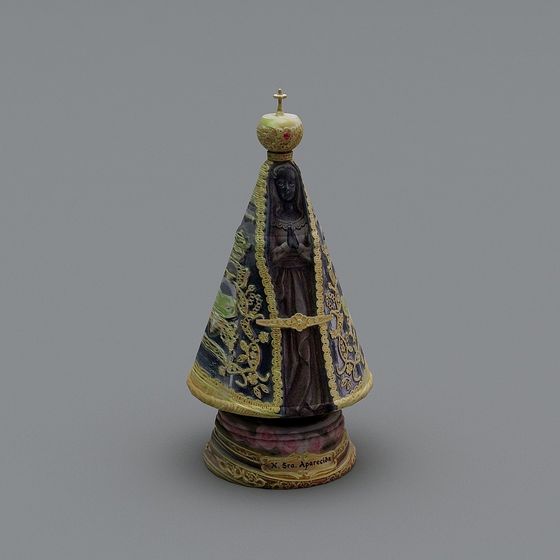 Religious ceramic statue with blue gold patterns and cross on grey background