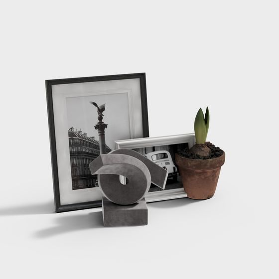 Modern home decor set with black and white frames, grey sculpture, potted plant on white background
