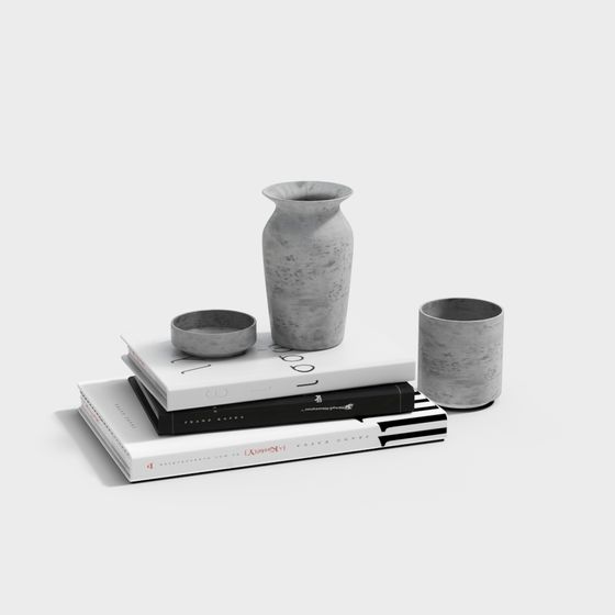 Set of grey stone vases and bowls on stacked books on white background