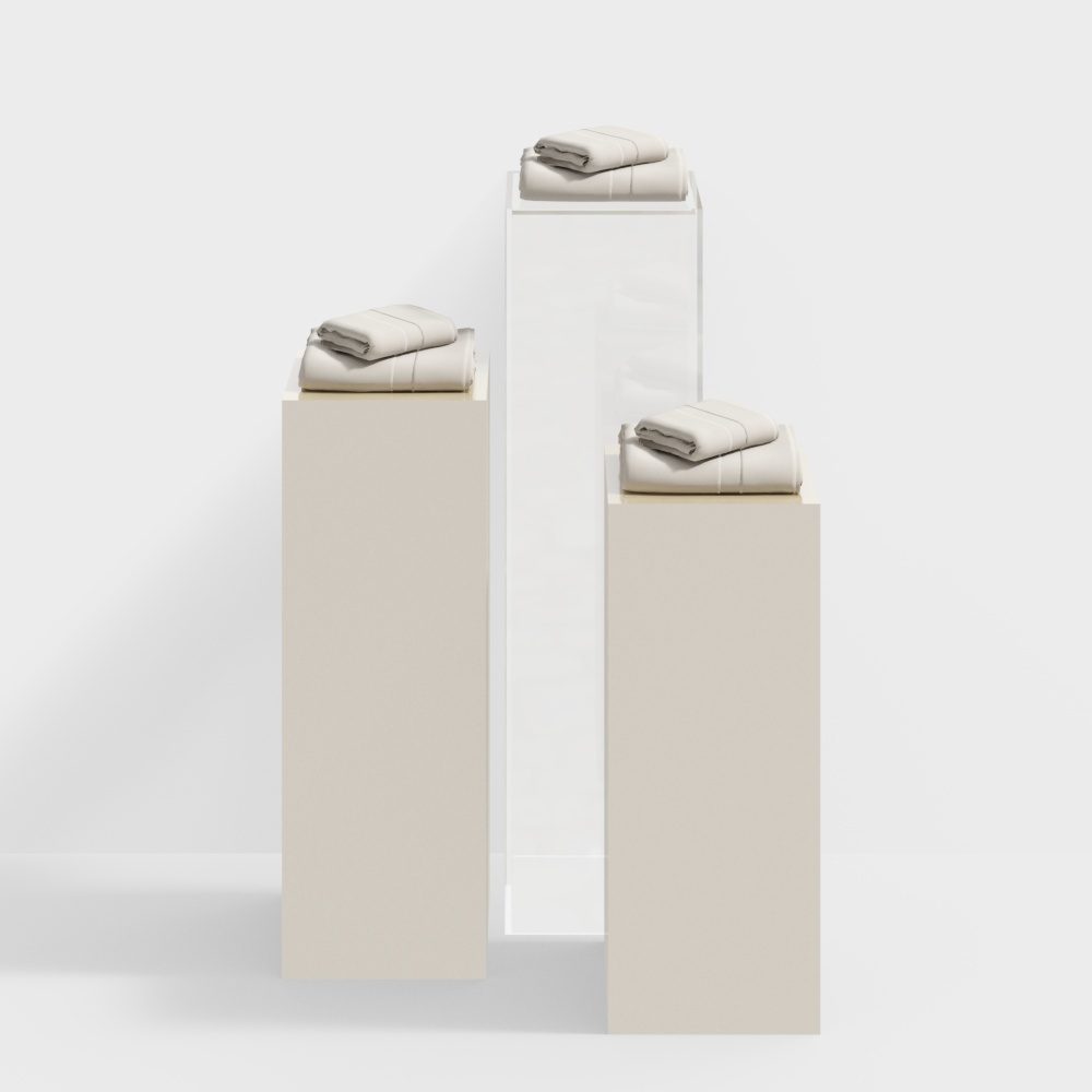 Three stacks of folded beige towels on white and beige display stands on white background