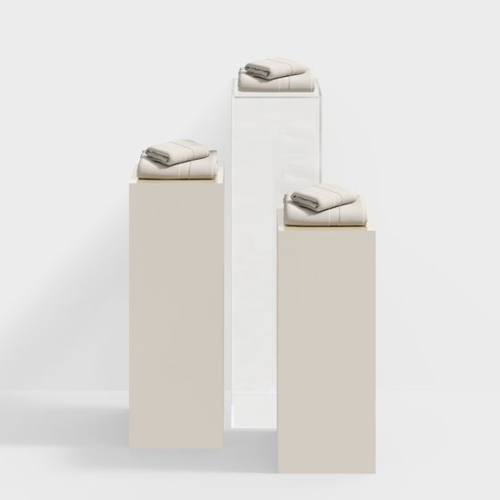 Three stacks of folded beige towels on white and beige display stands on white background
