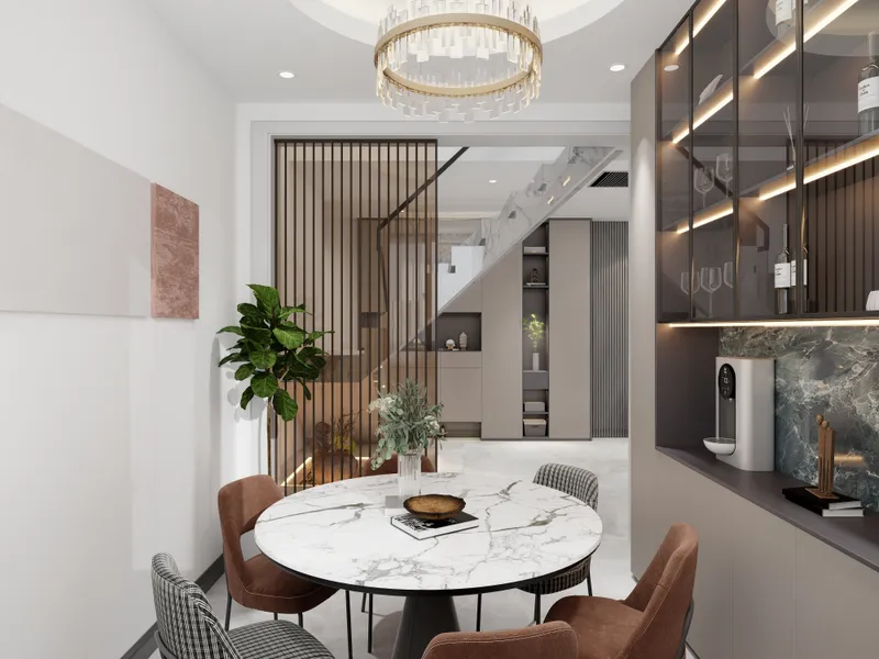 Modern dining room with marble table, brown chairs, green plant, partition, staircase, and ceiling light