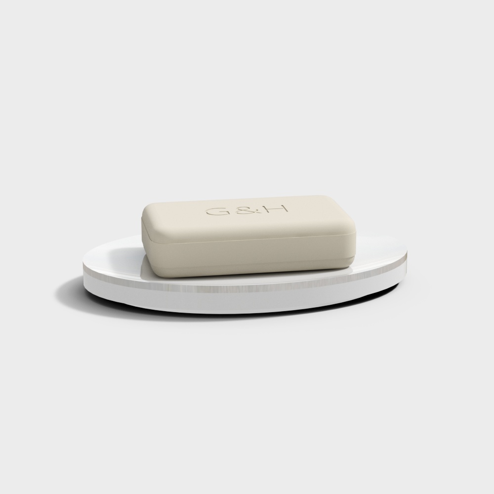 Cream colored bar of soap with G and H logo on white display stand on light grey background