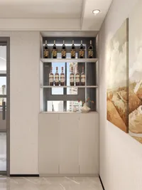 White storage cabinet with wine bottles on open shelves and warm colored wall art piece