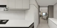 Modern white kitchen with stove and cabinets facing toward open plan dining and living area