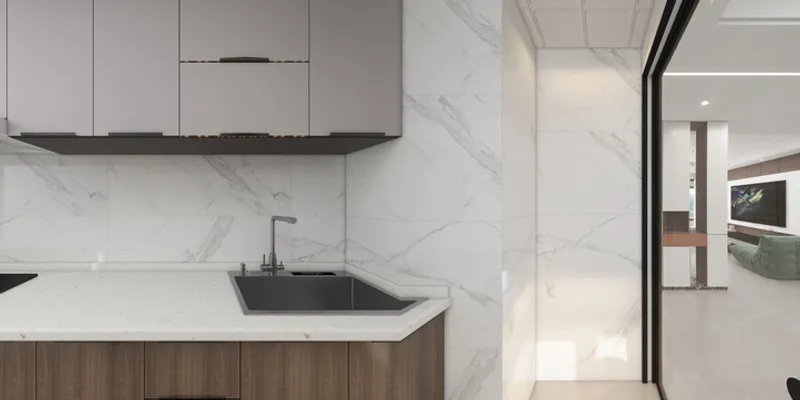 Modern kitchen with marble walls grey upper cabinets brown lower cabinets looking into living room