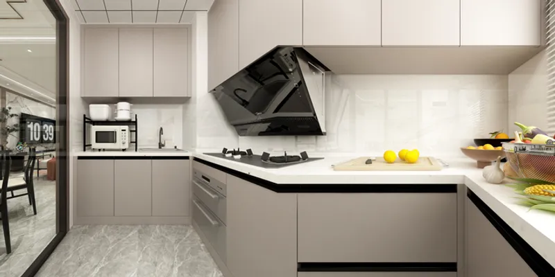 Modern kitchen featuring grey cabinets black stove microwave and lemons on white marble countertop surface