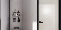 Minimalist bathroom wall featuring black shelves with toiletries and a modern white frosted glass door