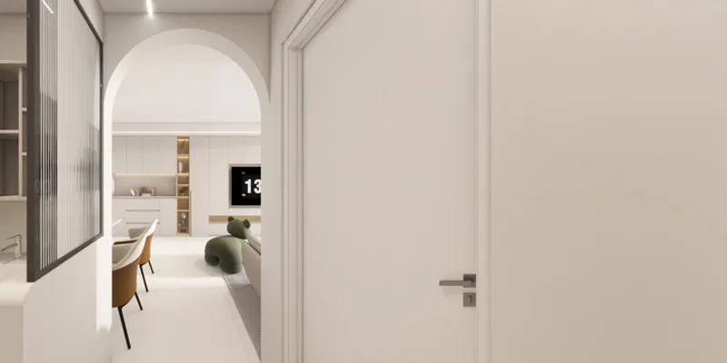 Arched doorway showing living room with white cabinets and a green bear shaped lounge chair