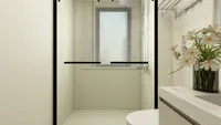 Close up of a shower area with window blinds shower head white toilet and flowers