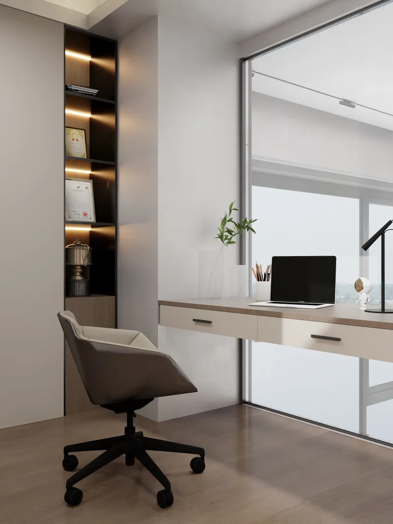 Modern home office featuring white desk grey chair laptop and wall shelves near large windows