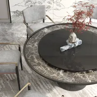 Close up of a round marble dining table with a small plant in a vase
