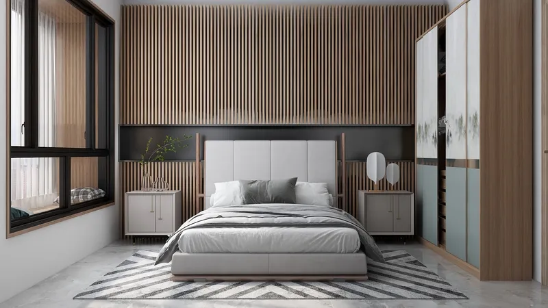 Modern bedroom featuring wood wall panel, grey bed, side cabinets, large wardrobe, and natural light