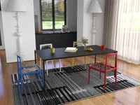 Close view of black table with colorful transparent chairs on a patterned grey area rug