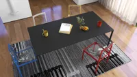 Top view of black dining table with yellow mug and colorful chairs on grey rug