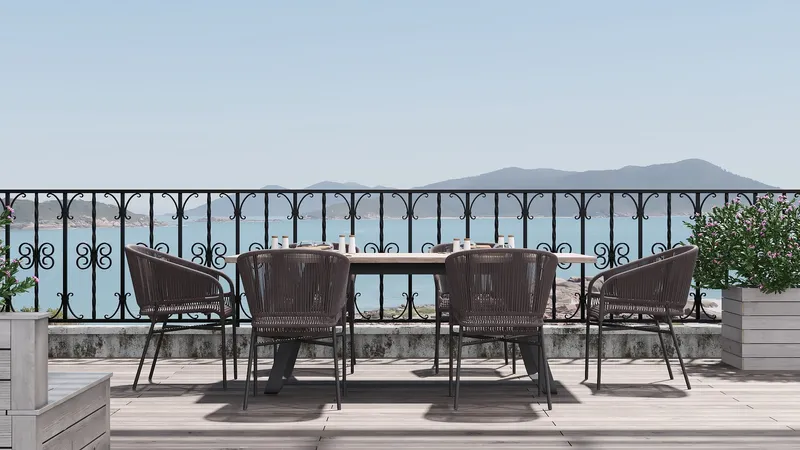 Outdoor wooden terrace with dining table, four chairs, black metal railing, and blue sea view