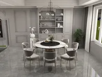 Modern dining area with round table, velvet chairs, grey wall panel, bookshelf, and large windows