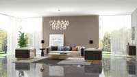 Luxury living room featuring comfortable sofa gold coffee table ceiling light and large glass windows
