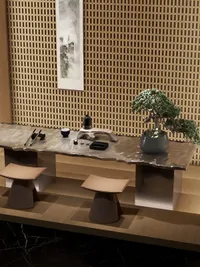 Angled view of wood table with tea set, bonsai tree, two stools, and wood wall