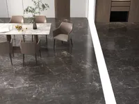 Marble dining table and brown chairs shown from above on a dark marble floor surface