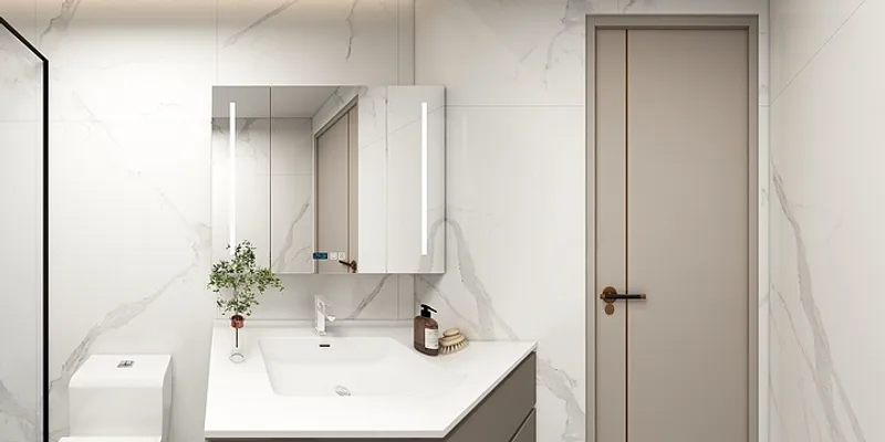 Modern bathroom with white marble walls mirror with lights white sink toilet and grey door