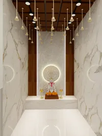 Modern prayer room featuring marble walls hanging gold bells and a statue with warm lighting