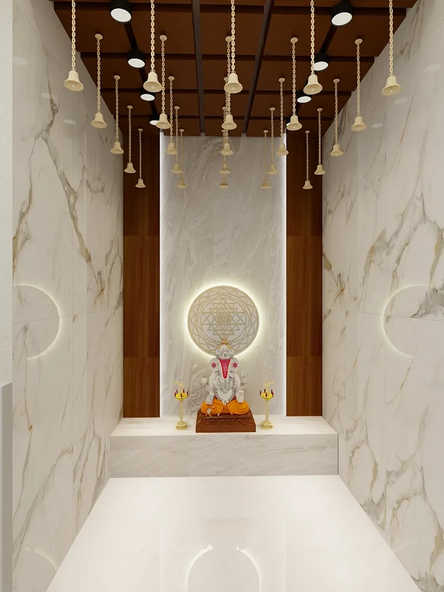 Modern prayer room featuring marble walls hanging gold bells and a statue with warm lighting
