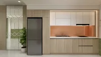 Modern kitchen with wooden cabinets white cupboards orange backsplash black fridge sink stove and plant