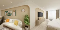 Open plan room with white sofa yellow pillows television on wooden cabinet and white bed