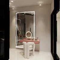 Dressing room featuring pink table, white modern chair, large lighted mirror, and small round light