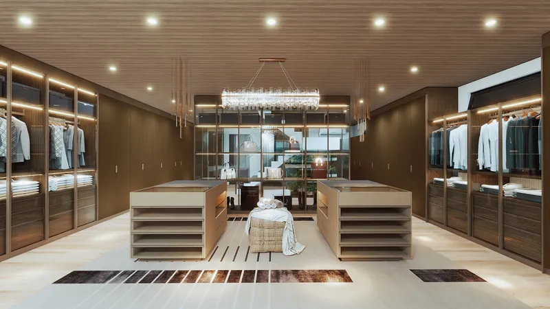 Spacious walk in closet featuring wood cabinets hanging clothes two islands and a ceiling light
