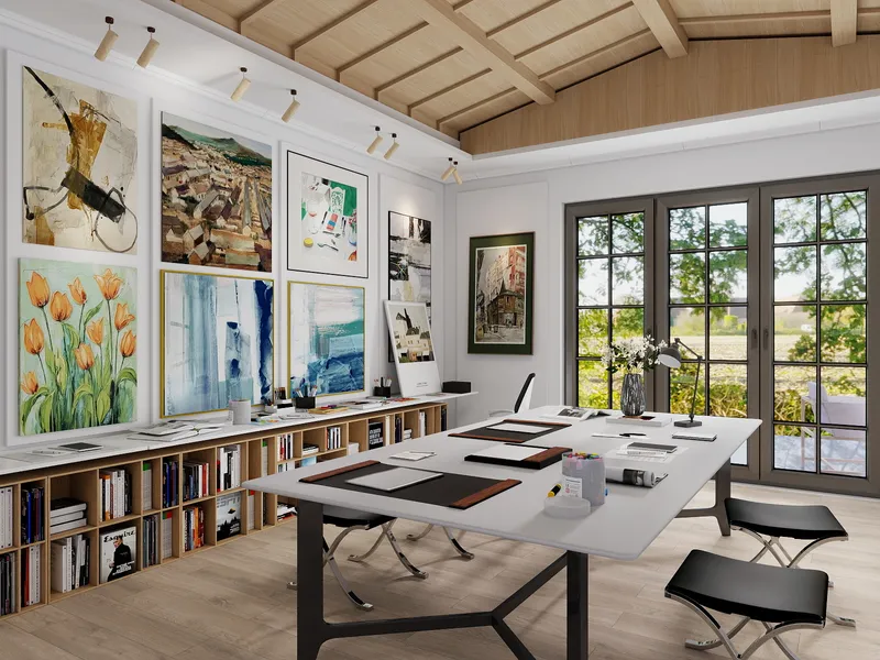 Bright art studio with large white table, wooden ceiling, many colorful paintings, and open bookshelves
