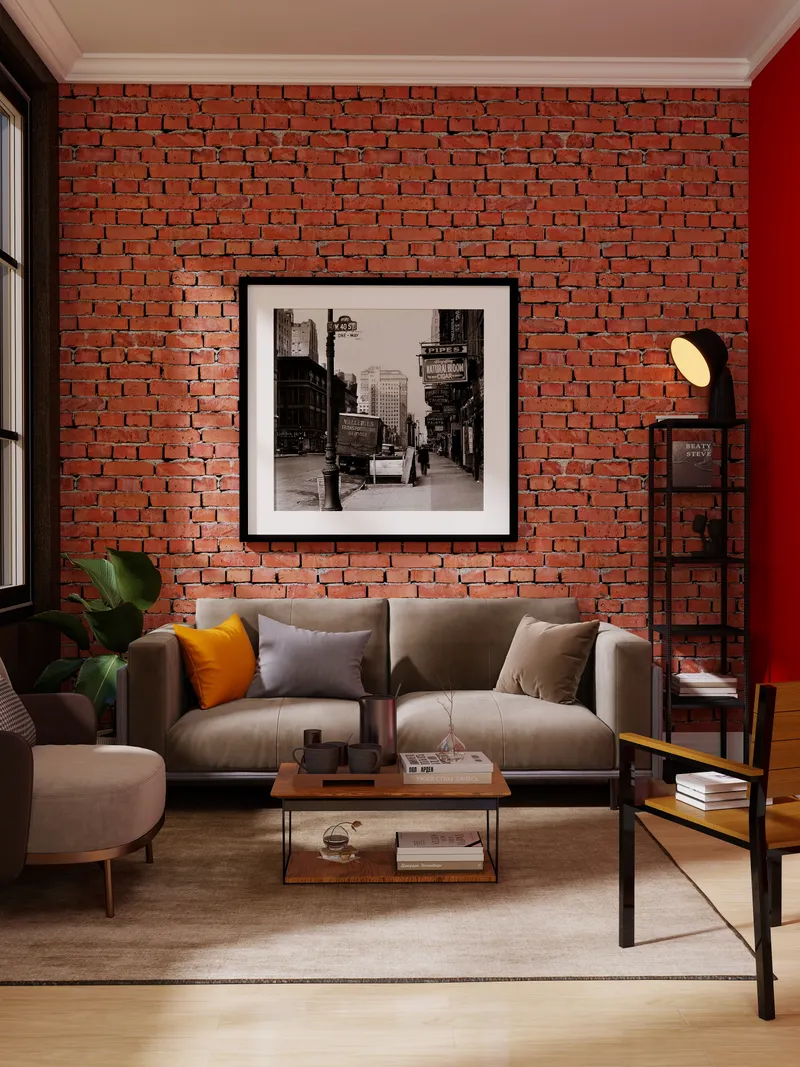 Living room with red brick wall, grey sofa, framed wall art, and a black lamp
