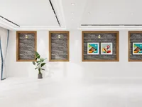 Modern white room with stone wall panel inserts featuring framed colorful art and green plant